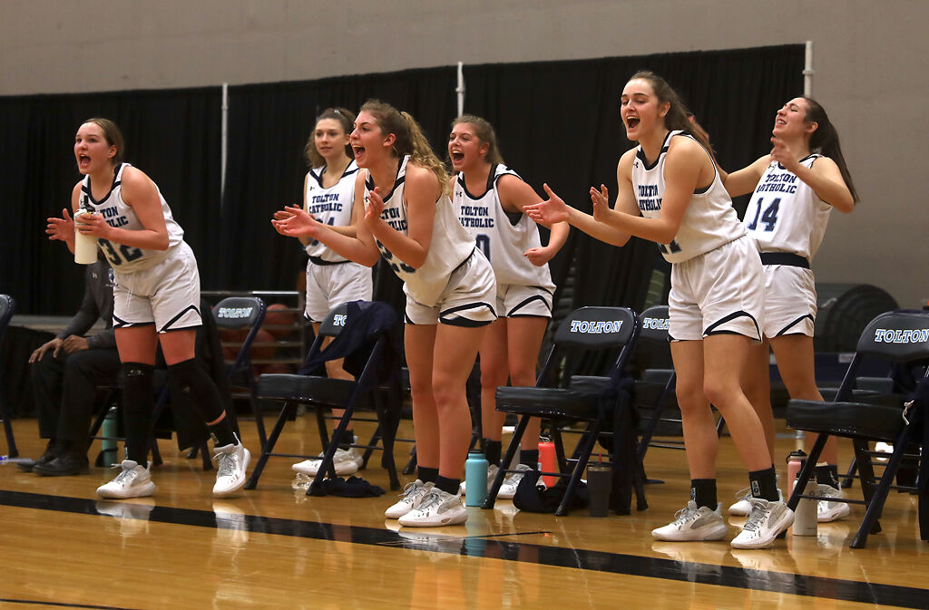 Players from Tolton High School cheer after a teammate makes a basket